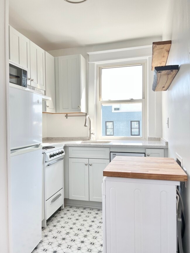 Cocina con detalle de tabla de carnicero sobre la lavadora y secadora. - 1451 Pennsylvania Ave SE Unidad 3