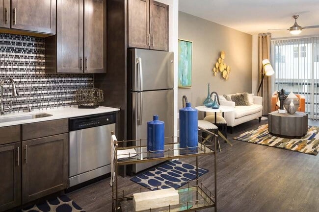 Modern Kitchen with Stainless Steel Appliances, Custom Cabinets, and Tiled Backsplash - The Grand at Legacy West