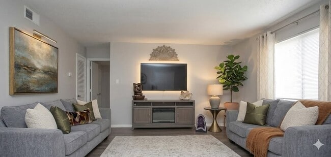 Elevate your living space at Richmond Hills Apartments with a modern, stylish layout that invites relaxation and comfort. The sleek furnishings and warm lighting create the perfect backdrop for your lifestyle. Explore your new home today! - Richmond Hills Apartments