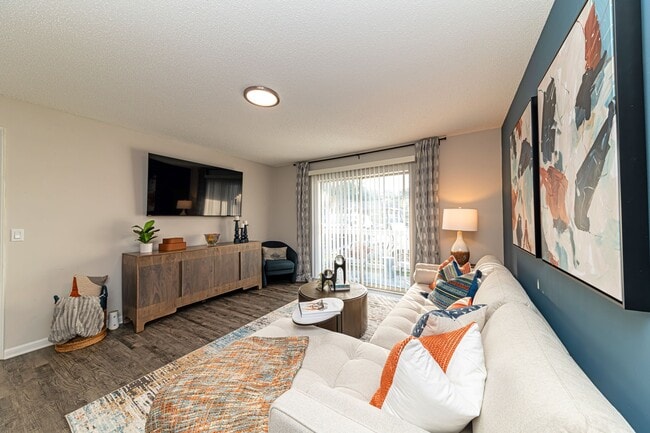 Spacious living room with hardwood-style flooring and overhead lighting