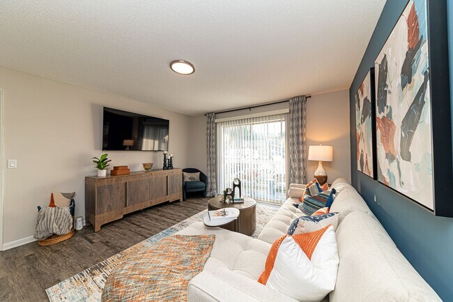 Amplia sala de estar con pisos estilo madera e iluminación cenital. - The Linden Apartment Homes