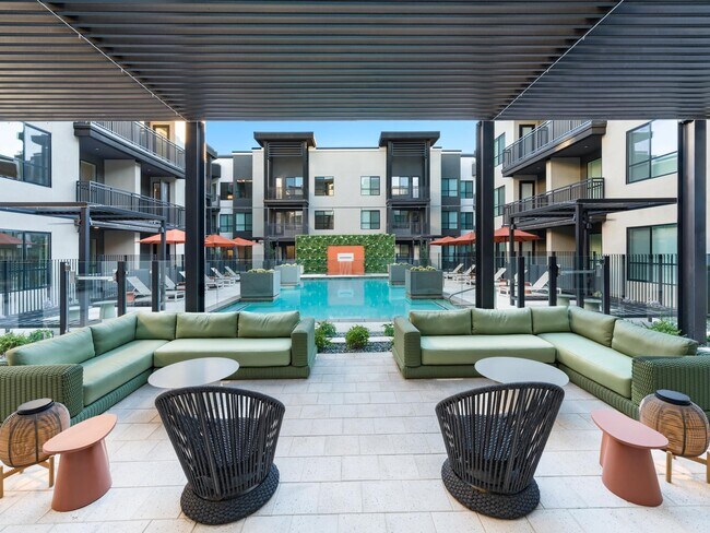 A covered poolside lounge at Modera Higley Commons, designed for relaxed gatherings with layered seating, shaded comfort, and a refined outdoor atmosphere. - Modera Higley Commons